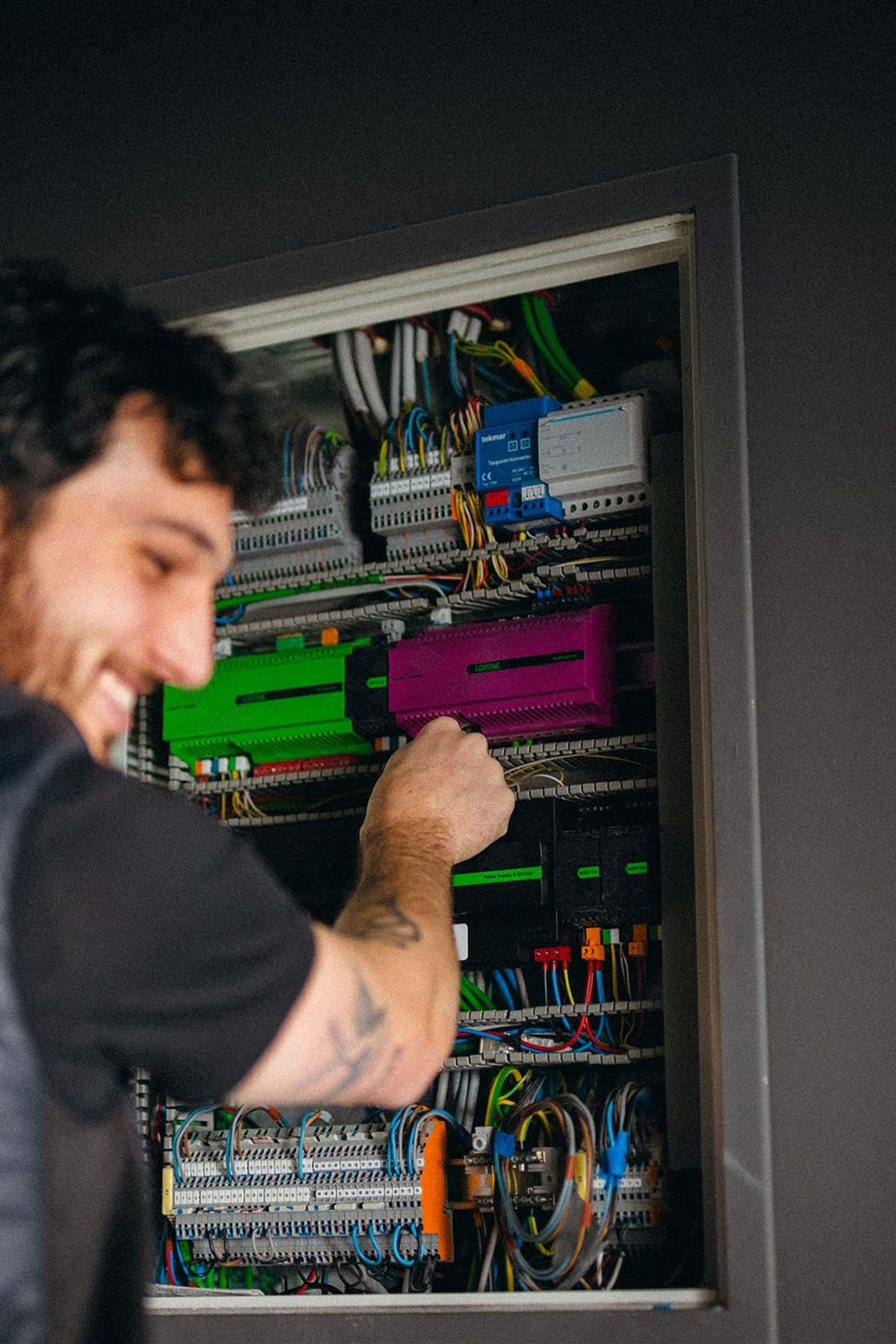 Loxone manufacturer photograph showing Miniserver and audio equipment being configured in a cabinet